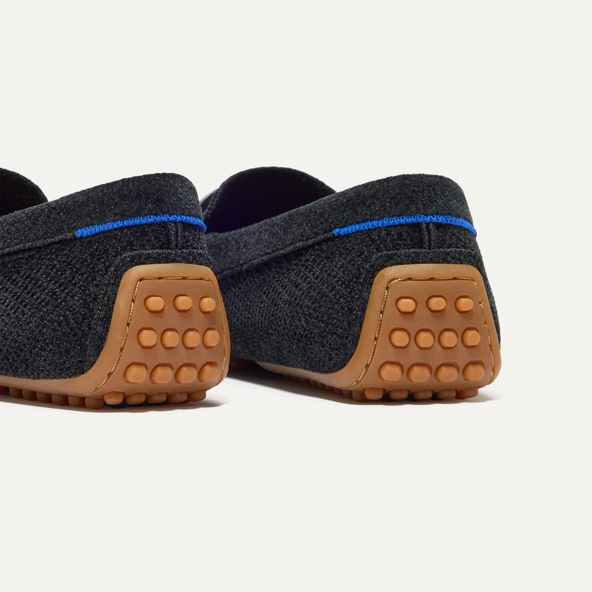 Close up of the heel of The Double Bit Driver in ReVelvet™ Black, with raised nub outsoles and Rothy's signature blue halo. 