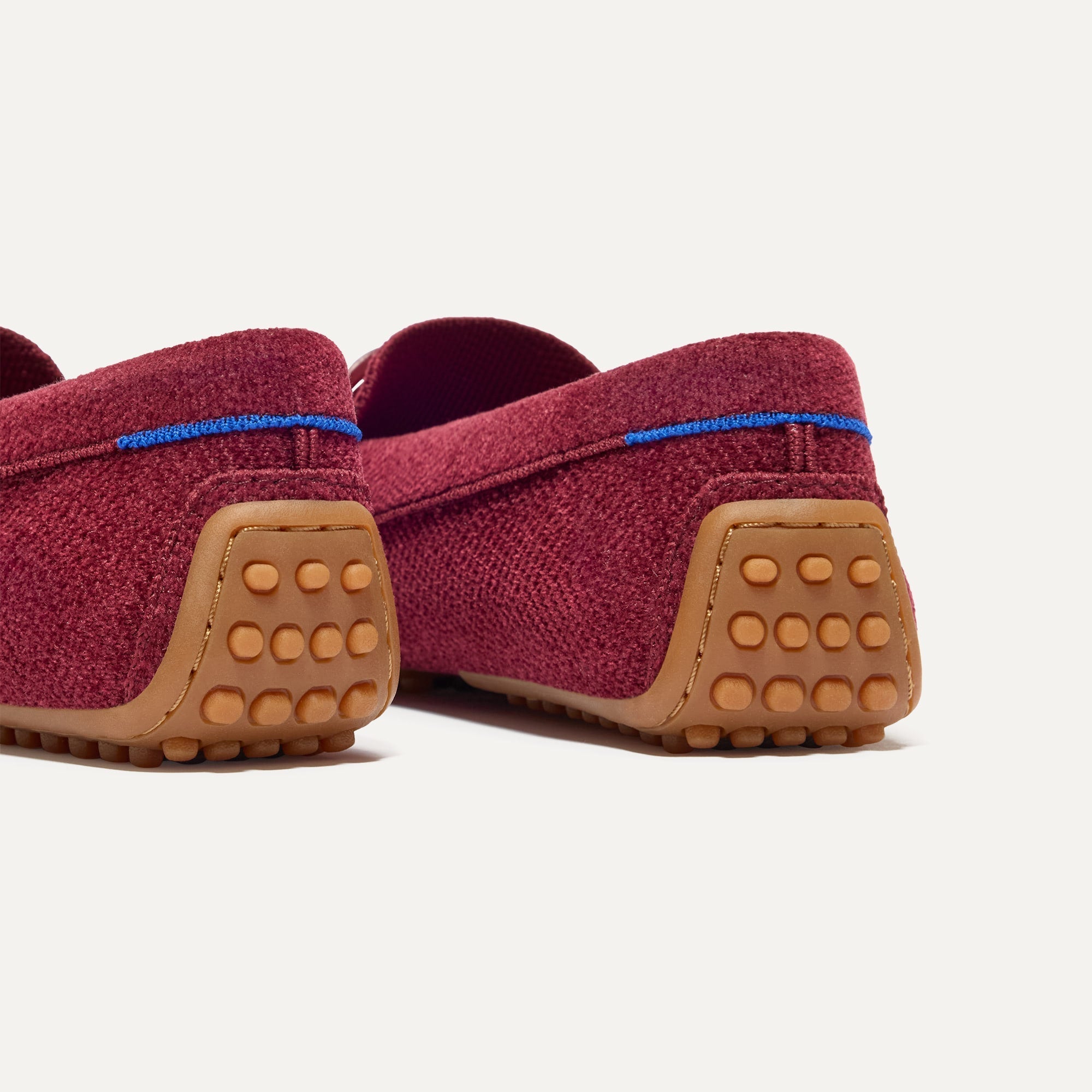 Close up of the heel of The Double Bit Driver in ReVelvet™ Cabernet, with raised nub outsoles and Rothy's signature blue halo. 