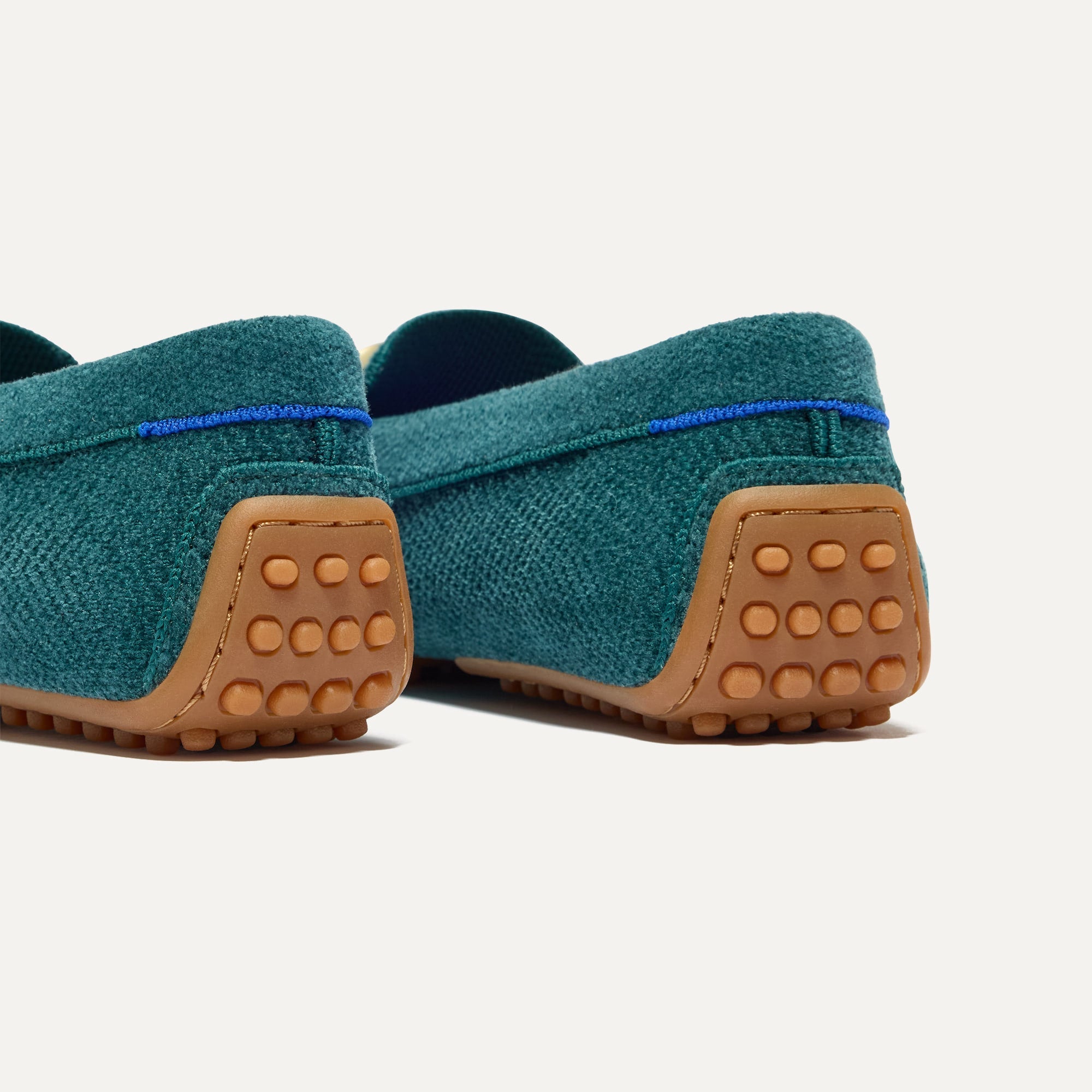 Close up of the heel of The Double Bit Driver in ReVelvet™ Everglade, with raised nub outsoles and Rothy's signature blue halo. 