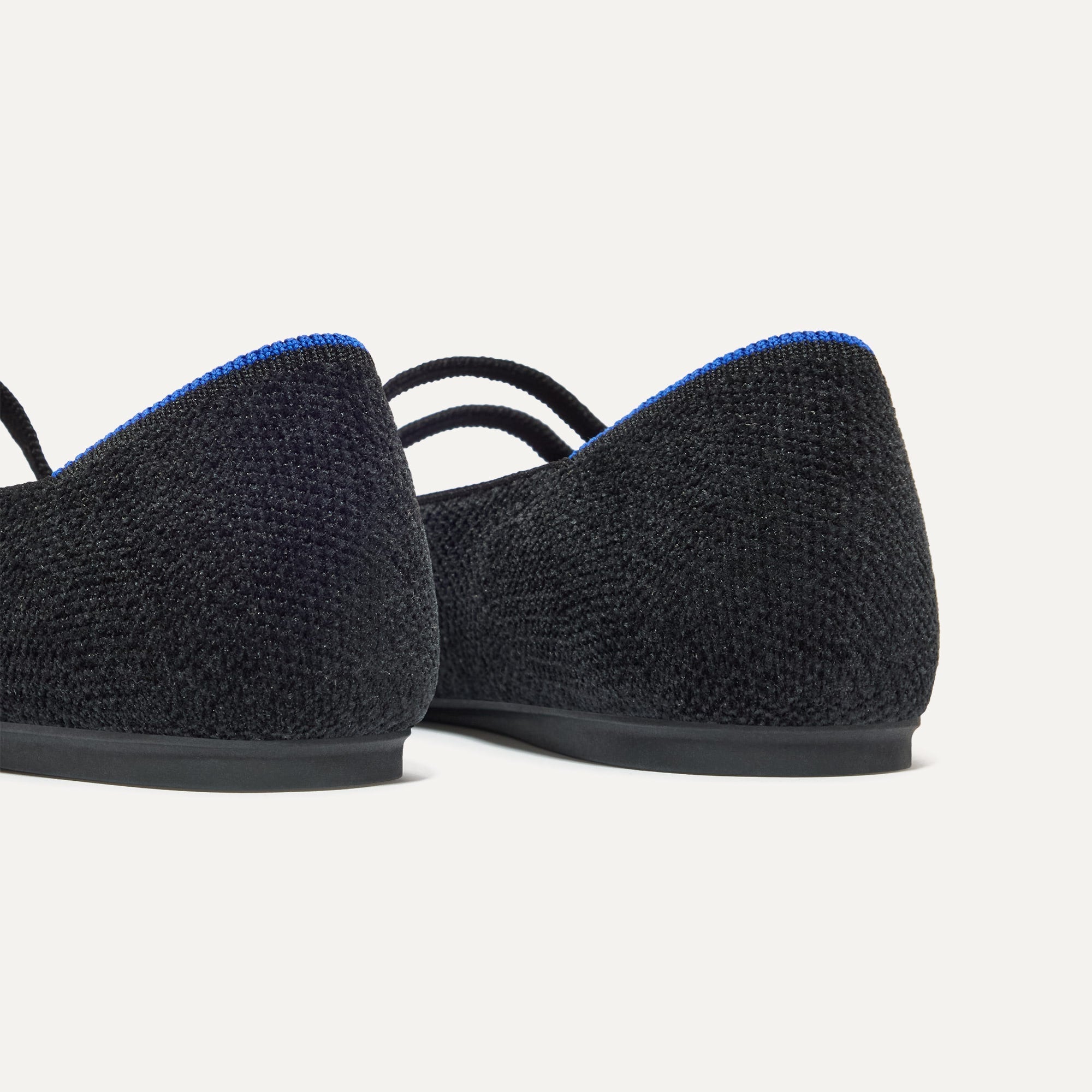 Close up of the heel of The Double Buckle Mary Jane in ReVelvet™ Black, with Rothy's signature blue halo.