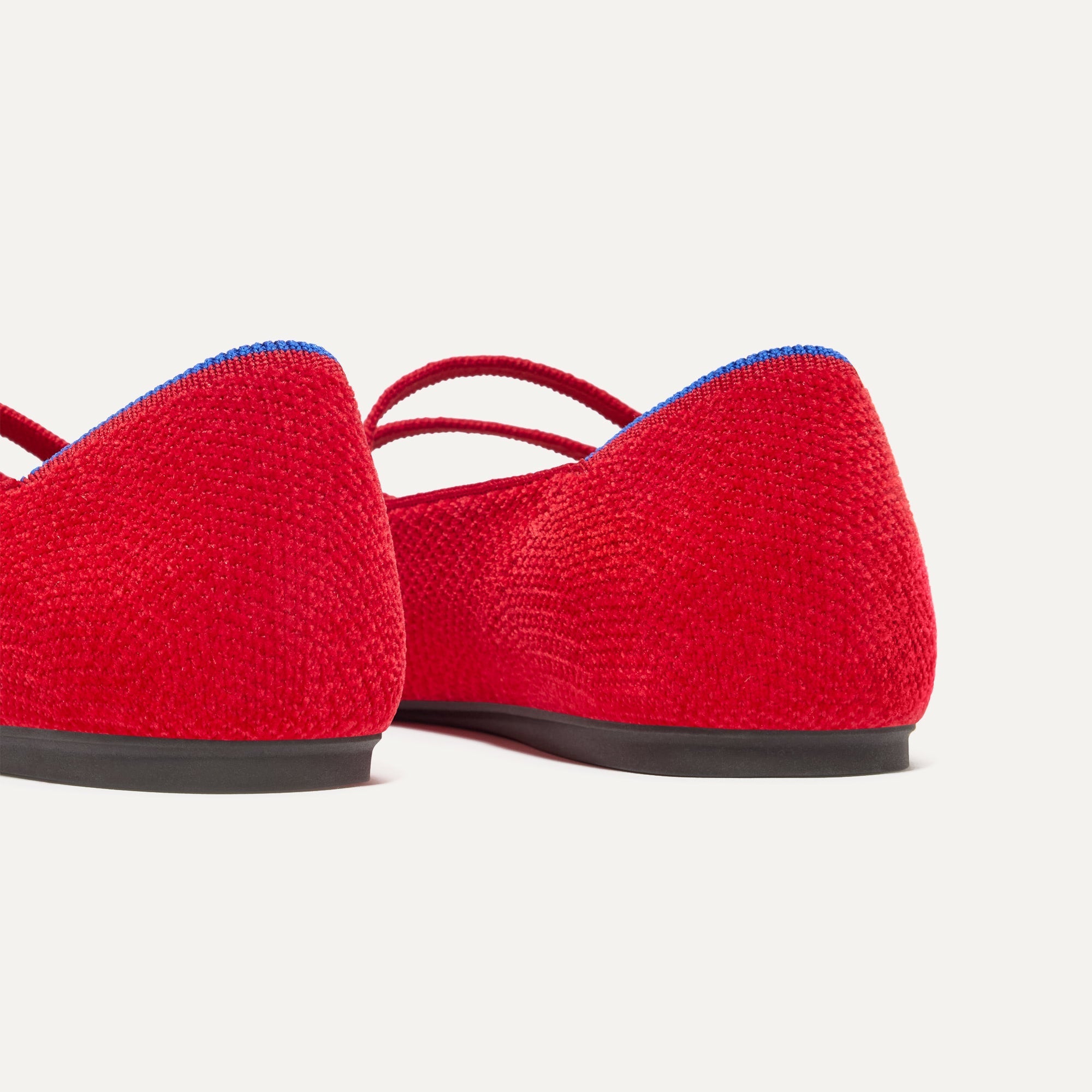 Close up of the heel of The Double Buckle Mary Jane in ReVelvet™ Red Crisp, with Rothy's signature blue halo.