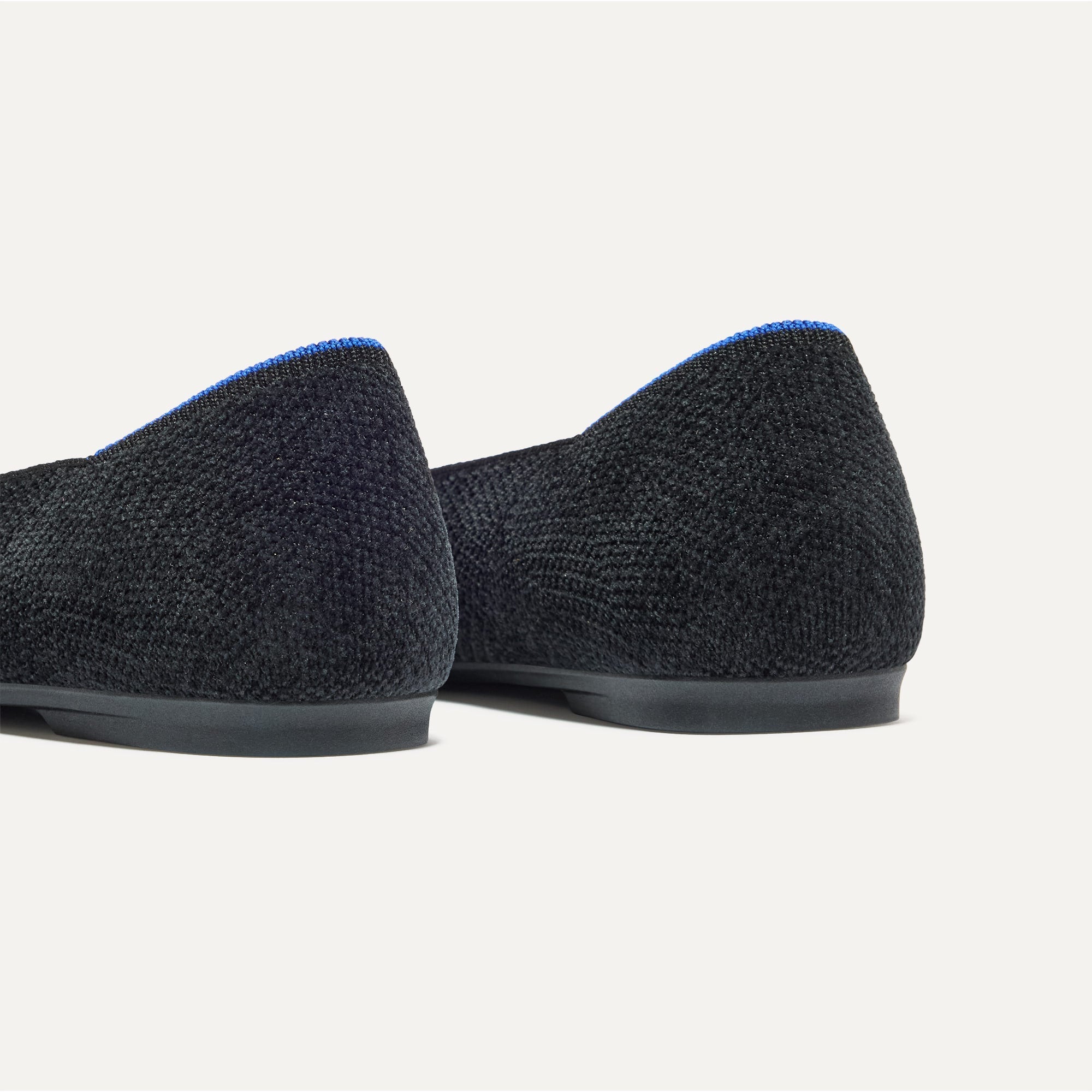 Close up of the heel of The Emblem Point II in ReVelvet™ Black, with Rothy's signature blue halo. 