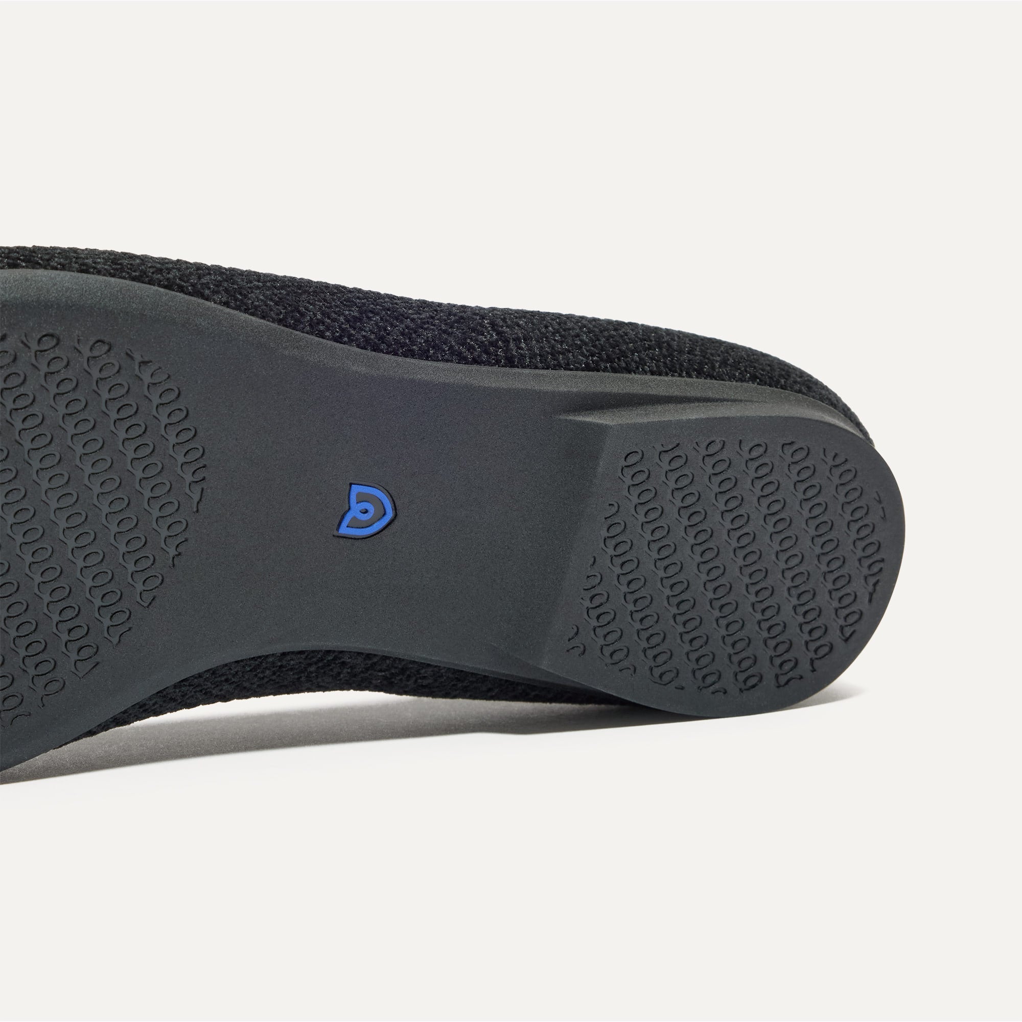 Close up of the outsole of The Emblem Point II in ReVelvet™ Black, shown in a diagonal view. 