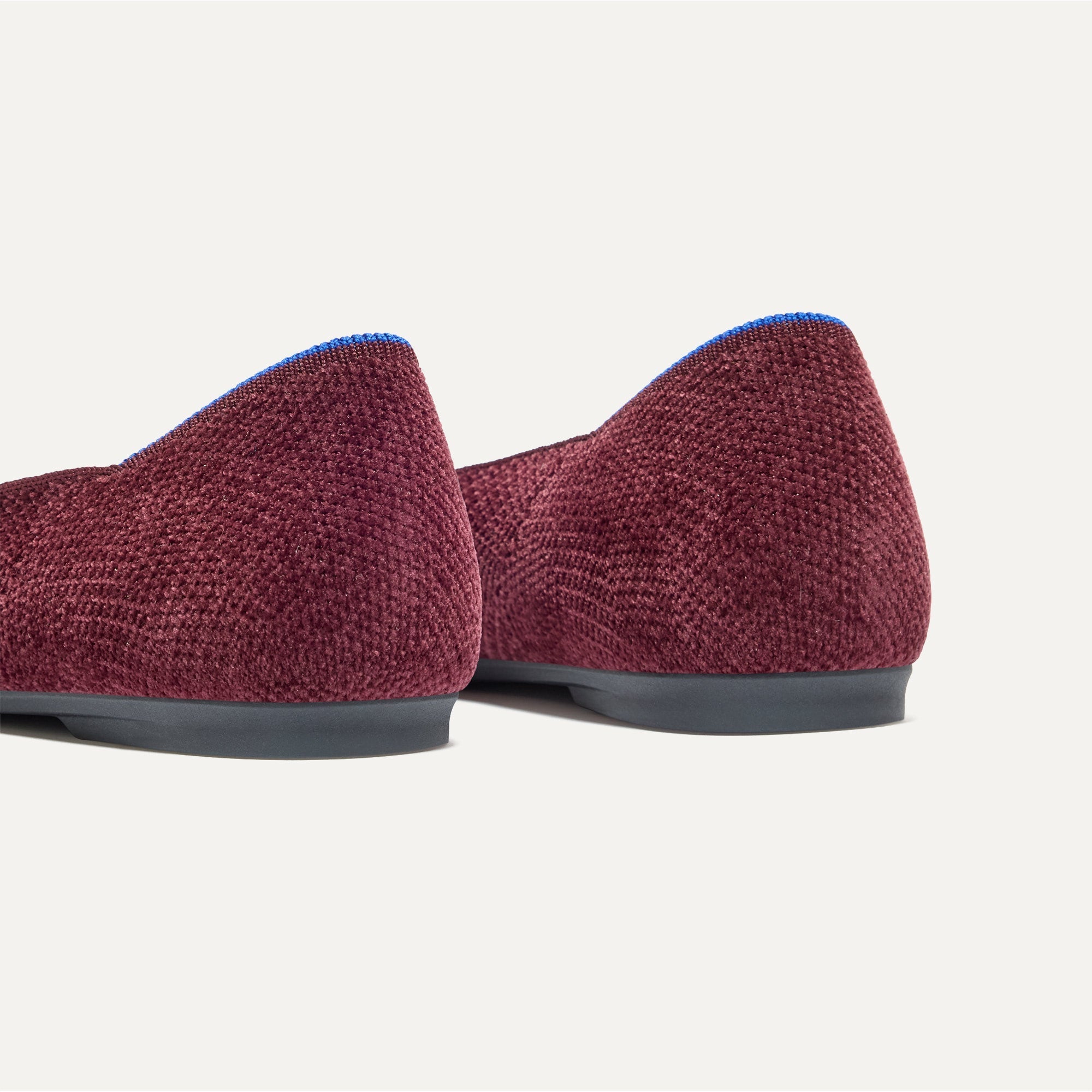 Close up of the heel of The Emblem Point II in ReVelvet™ Syrah, with Rothy's signature blue halo. 
