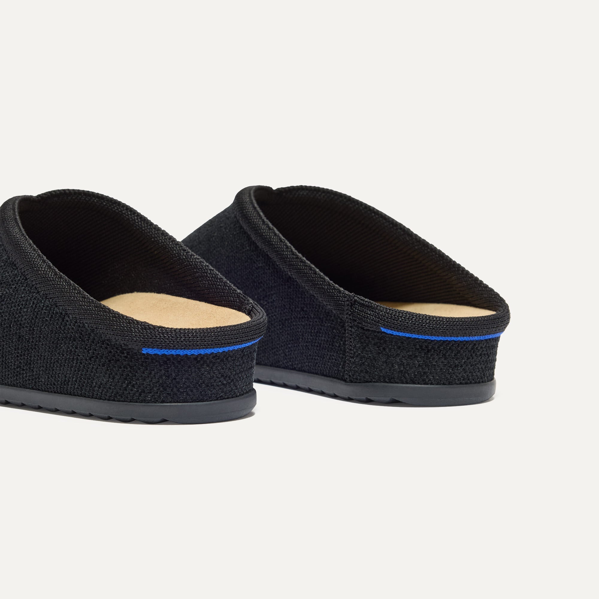 Close up of the heel of The Casual Clog in ReVelvet™ Black, with Rothy's signature blue halo. 