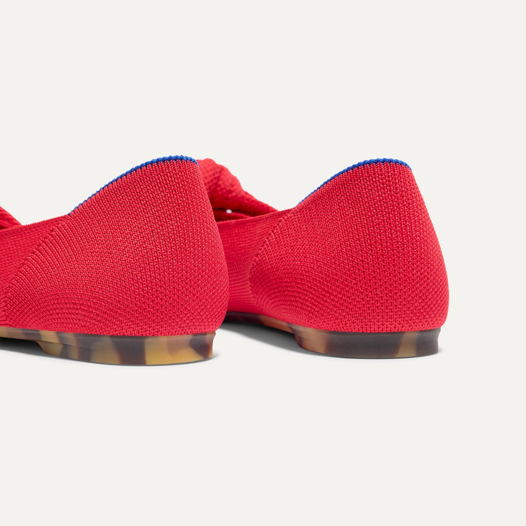 Close up of the heel of The Knot Ballet Flat in Lollipop Red, with Rothy's signature blue halo. 