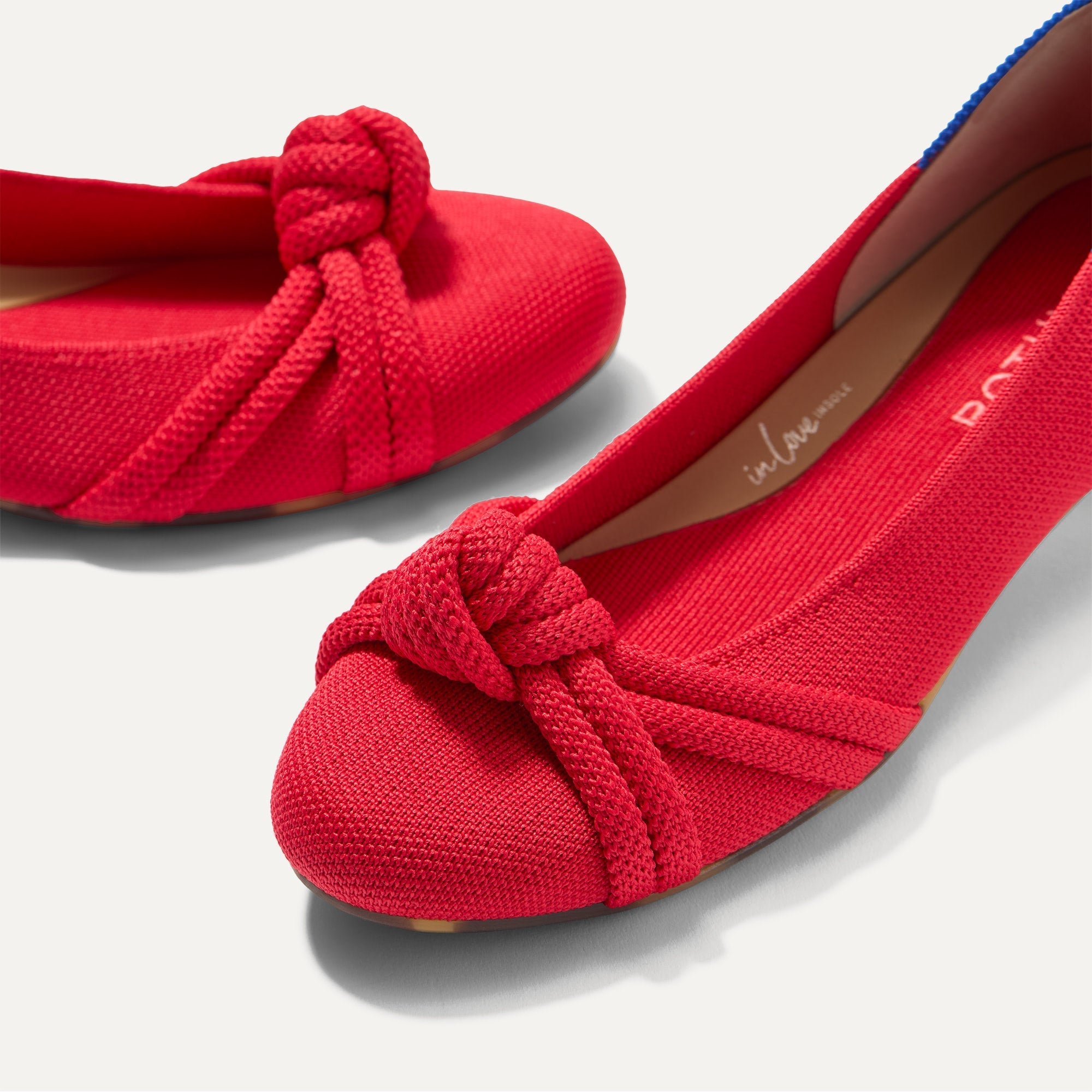Close up of the rounded toe and knotted detail of The Knot Ballet Flat in Lollipop Red.