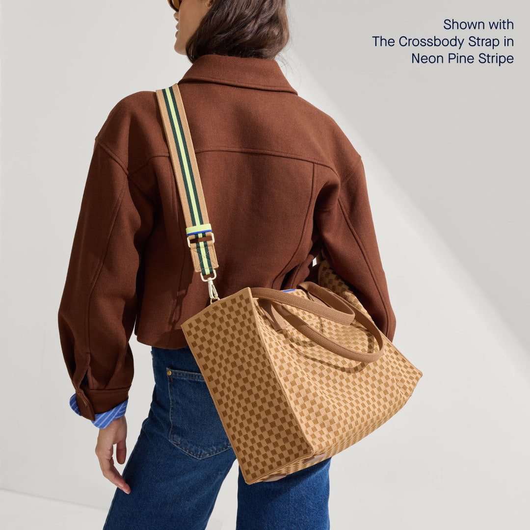 The Classic Tote in Hazelnut, worn as a crossbody by a model, paired with The Crossbody Strap in Neon Pine Stripe.