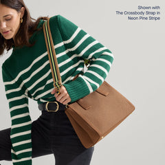 The Classic Handbag in Sierra Brown being carried by a model shown paired with The Crossbody Strap in Neon Pine Stripe.