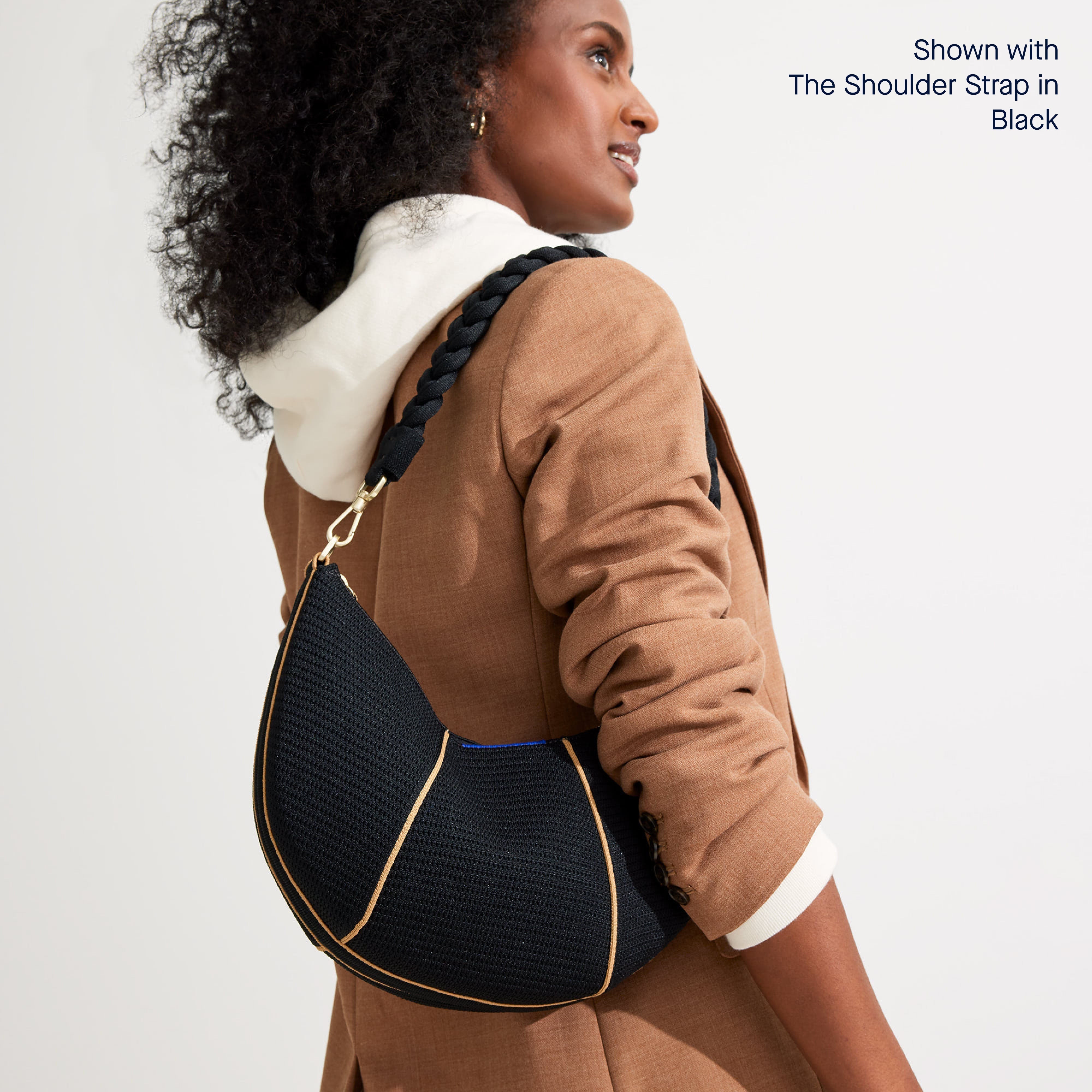 Model wearing The Crescent Bag in Black on her shoulder, shown with The Shoulder Strap. 