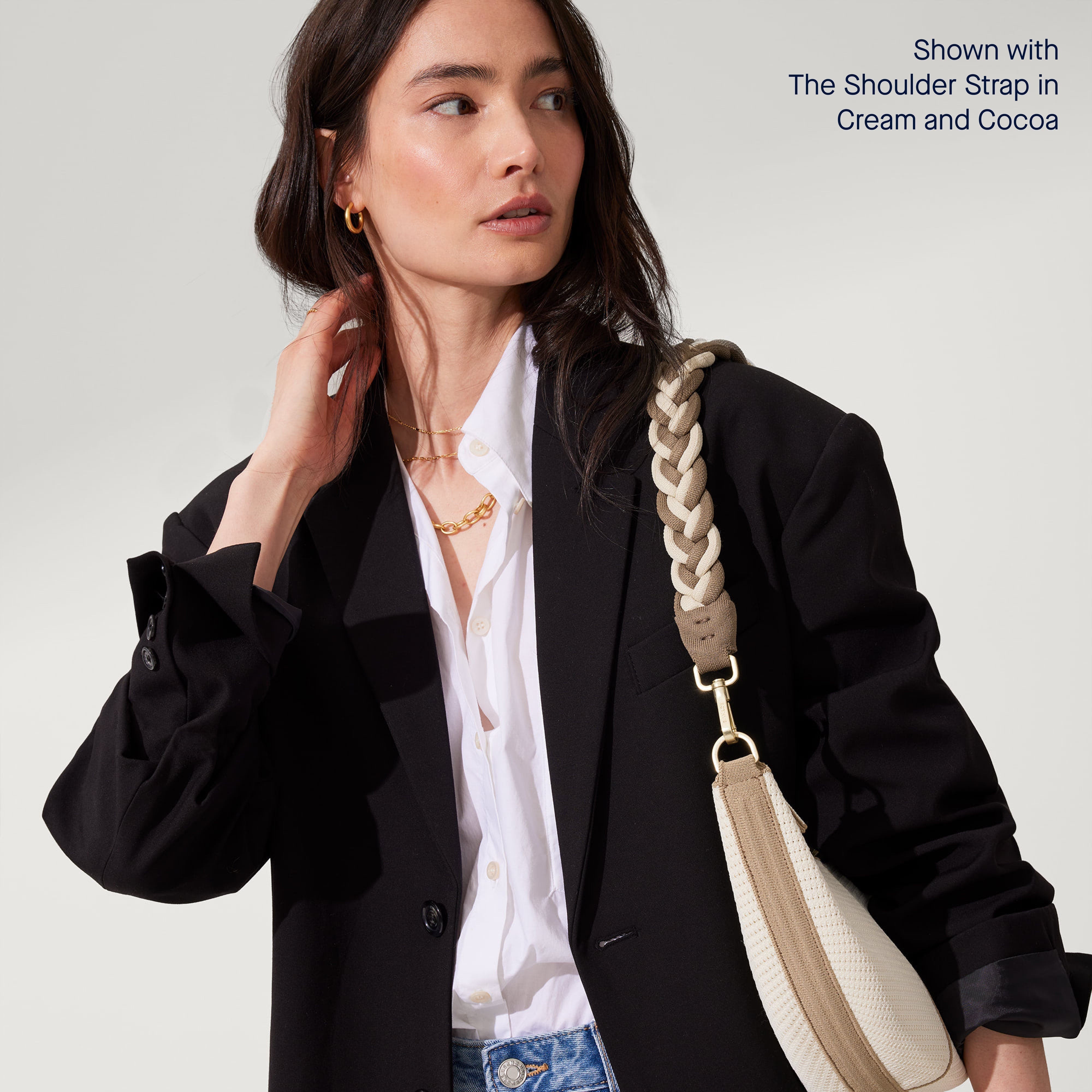 Model wearing The Crescent Bag in Celestine on her shoulder, shown with The Shoulder Strap. 